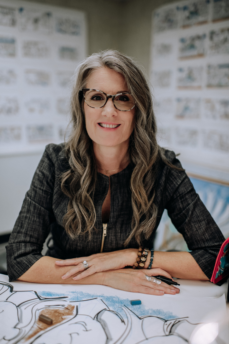 christina merkley visual coach portrait sitting at a desk