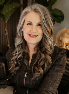 Christina Merkley portrait in her office, smiling at the camera