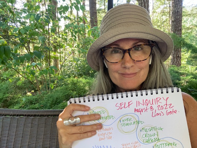 christina merkley in her garden holding a self inquiry map