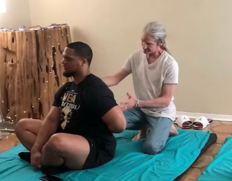David Tiejie working with a client in his Yoga and Thai massage studio.