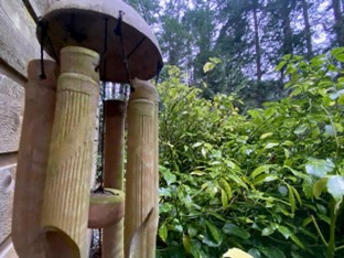 Bamboo windchimes against the backdrop of the green forest.